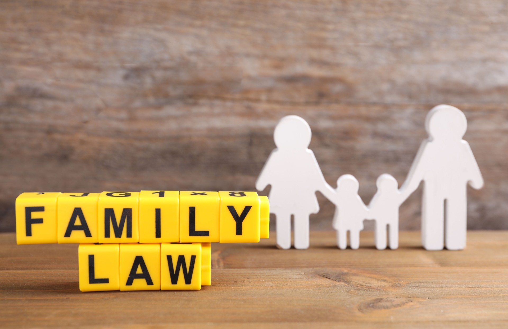 Cubes with letters and family figure on wooden table. Family law concept